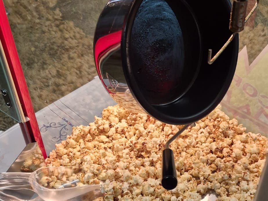Le chaudron de la machine à popcorn qui bascule et déverse le popcorn sur le plateau