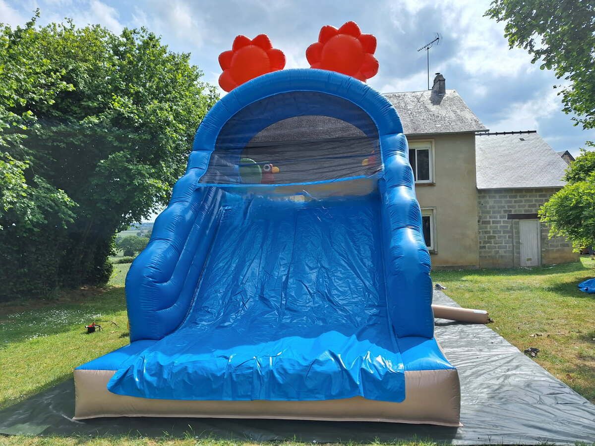Le grand toboggan bleu de la structure gonflable Tropicale, vu de face