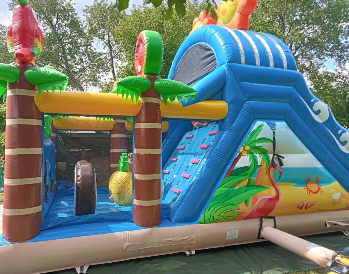 Intérieur de la structure Tropicale : mur d’escalade, ananas et décor de plage avec flamant rose